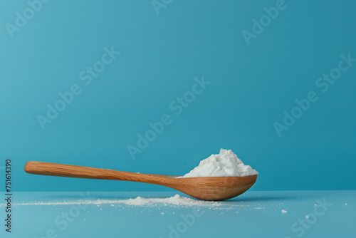A wooden spoon with white flour lies on a blue background