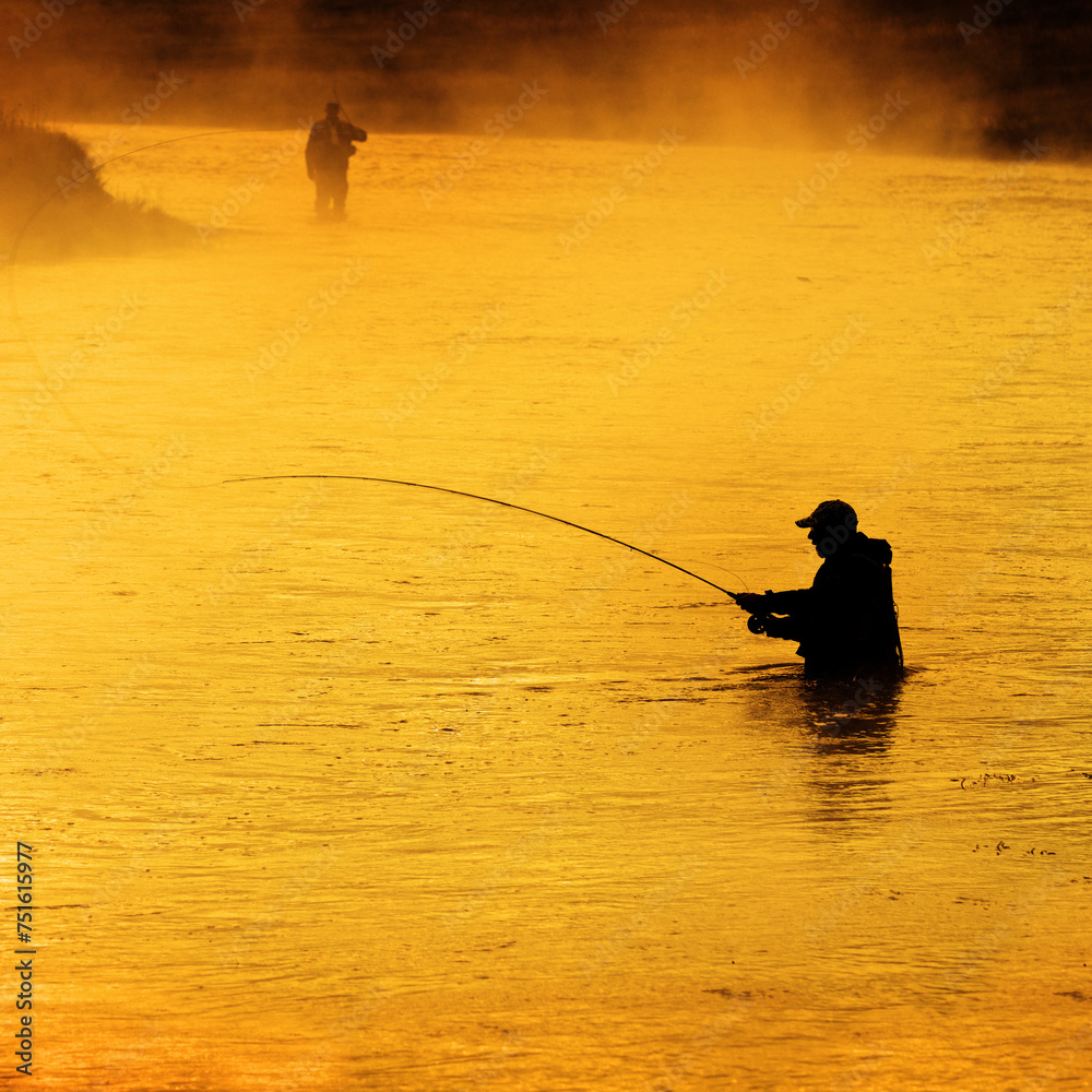 Silhouette of Man Flyfishing in River Golden Morning Light