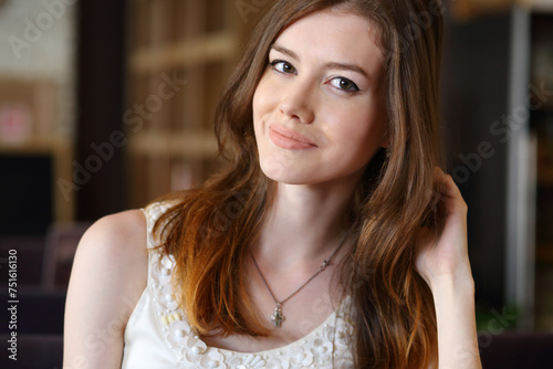 Young beautiful woman with long hair poses in cafe  shallow dof
