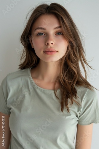 A wide shot capturing a young white woman in a smooth, unwrinkled light green round neck t-shirt against a pristine white backdrop photo