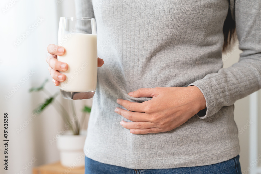 asian young woman having a stomachache, abdominal pain or digestive, hand in holding belly after