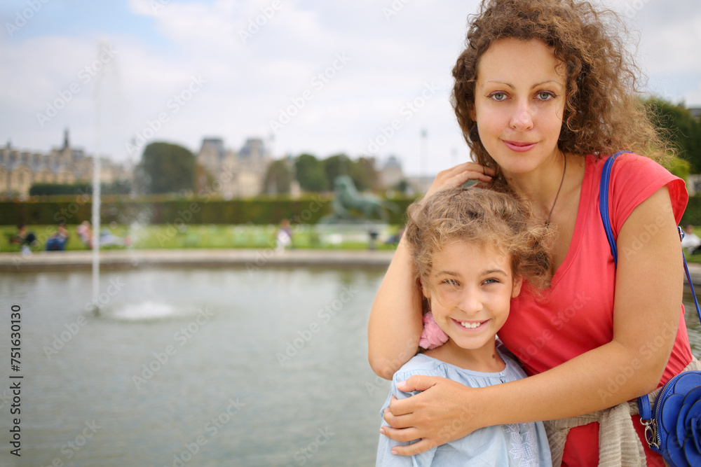 Portrait of a beautiful woman and girl in a park near the fountain in Paris Portrait of a beautiful woman and girl in a park near the fountain in Paris