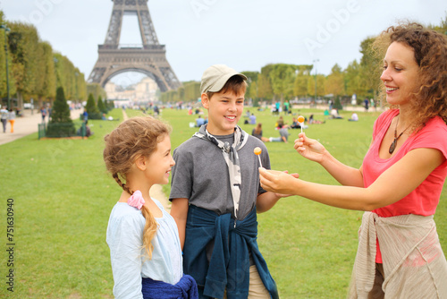 Mother, son and daughter with lollipops near in Paris