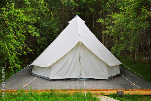 White tent for guests are hosted on wooden podium on camping © Pavel Losevsky