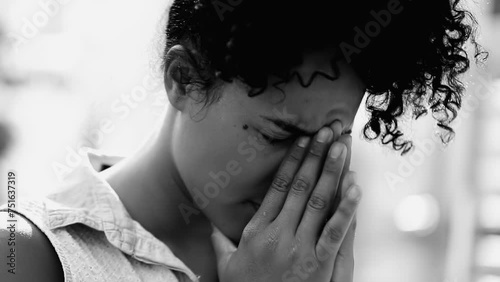 One overwhelmed young black woman feeling mental pressure struggling with mental illness and life's difficulties in dramatic black and white, monochrome photo