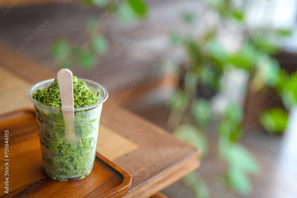 Close up glass of matcha granita on wooden table at cafe, copy space concept. Close up glass of matcha granita on wooden table at cafe, copy space concept.