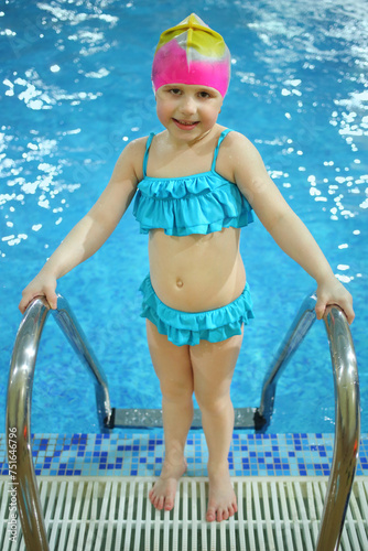 Little girl in a swimming hat out of the pool