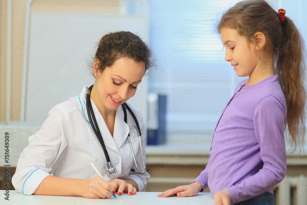 Health worker writing prescription for young girl in exam room, focus on woman Health worker writing prescription for young girl in exam room, focus on woman