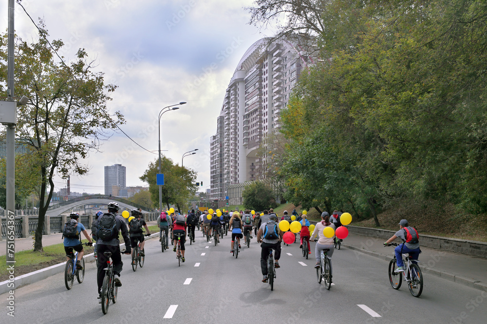 Obraz premium Bike ride in honor of city of Moscow,cyclists with yellow and red balloons, view from back