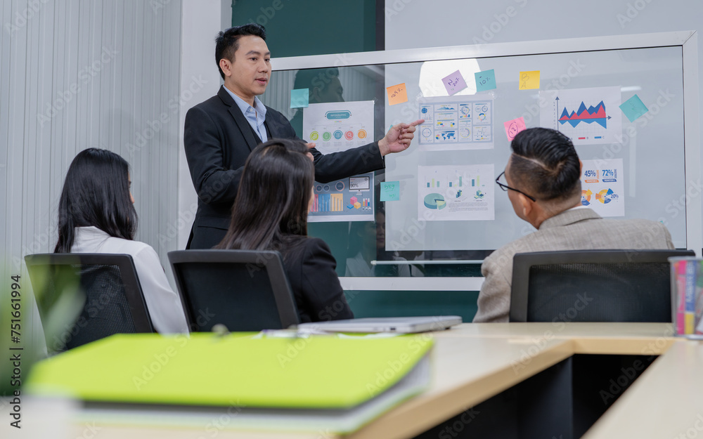 A man is giving a presentation to a group of people in a conference room. The presentation is about graphs and charts A man is giving a presentation to a group of people in a conference room. The presentation is about graphs and charts