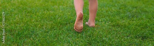 Child feet on the grass. Selective focus.