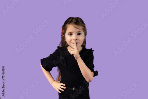 The picture of a small and beautiful girl caught while showing a gesture with her finger to make peace, tsss, she taking care of the peace around her. photo