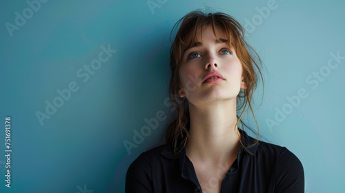 Pensive young woman against blue