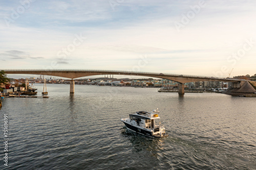 Fishing boat crossing under a bridge