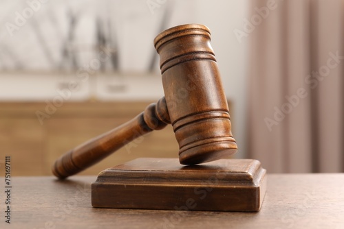 Wooden gavel and sound block on table indoors, closeup