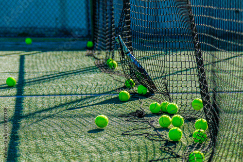 Bright tennis balls on a sunlit court, casting dramatic shadows. Perfect for sports themes