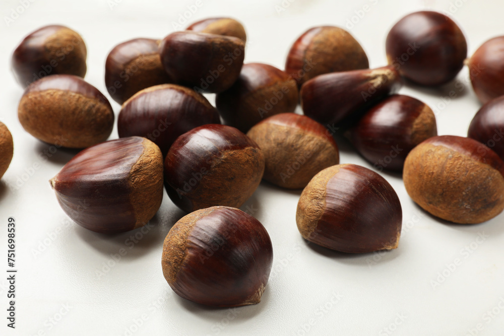 Sweet fresh edible chestnuts on white table, closeup Sweet fresh edible chestnuts on white table, closeup
