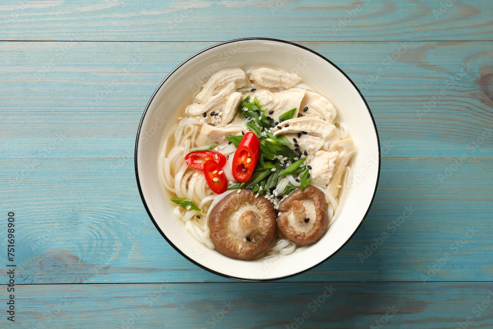 Delicious ramen with meat and mushrooms in bowl on light blue wooden table, top view. Noodle soup Delicious ramen with meat and mushrooms in bowl on light blue wooden table, top view. Noodle soup