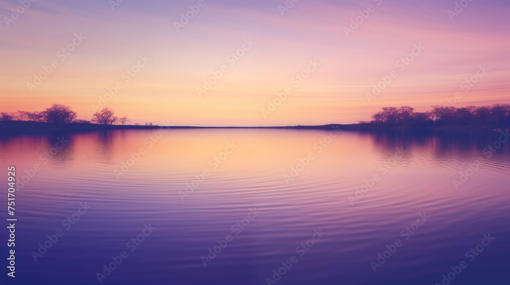 Serene sunset over tranquil lake: Peaceful sunset casting purple and orange hues over calm waters with silhouetted trees