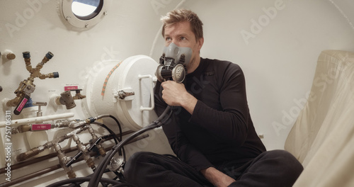 Patient inside white hyperbaric chamber after trauma