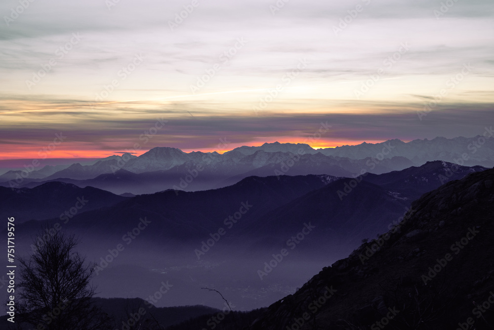 Staring at the horizon. Mountain range silhouette. Suggestive sunset over the alps, from Mottarone mountain (Omegna side). Piedmont - Italy.