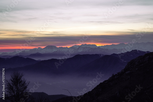 Fototapeta Naklejka Na Ścianę i Meble -  Staring at the horizon. Mountain range silhouette. Suggestive sunset over the alps, from Mottarone mountain (Omegna side). Piedmont - Italy.