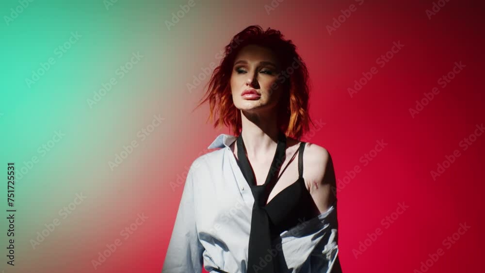 Woman with red hair in a dynamic pose against a split red and teal ...