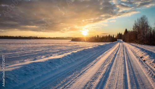 beautiful view of the sunset in the evening on the country snowy road © Ryan