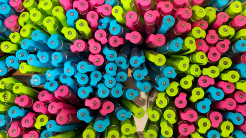 Abstract background of multicolored caps of plastic pens. A set of several liners, markers and colored markers of different colors, top view.