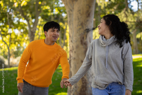 Happy woman and boyfriend holding hand in a park.Couple having fun together with love