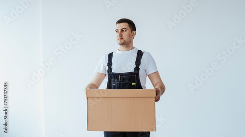 Delivery man with a box. Courier in uniform t-shirt service fast delivering orders. Young guy holding a cardboard package. Character on isolated white background for mock up design.
