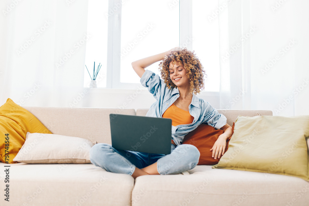 Smiling Woman Freelancing from Home: Laptop, Technology, and Relaxation in Cozy Living Room Smiling Woman Freelancing from Home: Laptop, Technology, and Relaxation in Cozy Living Room