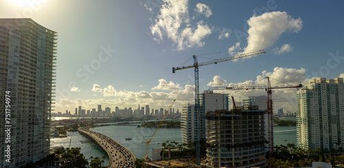 Aerial view of new developing residense in american urban area. Tower cranes at industrial construction site in Miami, Florida. Concept of housing growth in the USA photo