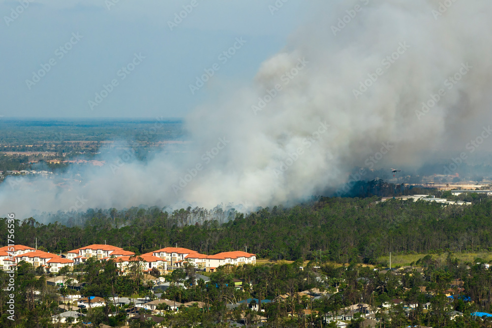 Aerial view of strong wildfire burning severely in North Port city, Florida. Natural disaster during dry season in jungle woods