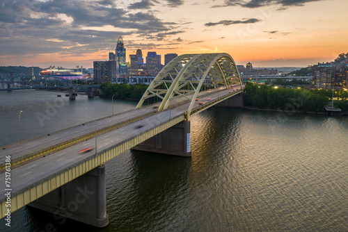 Slika na platnu Downtown district of Cincinnati city in Ohio, USA at night with driving cars traffic on Daniel Carter Beard Bridge and brightly illuminated high skyscraper buildings