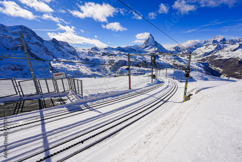 Snowy cogwheel railroad equipped with a rack rail using the Abt system in the Gornergrat summit train station facing the Matterhorn, Canton of Valais, Switzerland