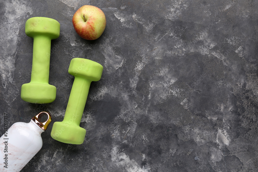 Dumbbells, bottle for water and apple on black background Dumbbells, bottle for water and apple on black background