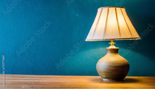lampshade lamp on table on blue wall background photo