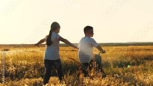 happy girl runs catching up with boy  child boy rides bicycle  son pedals  girl daughter plays airplane pilot  childhood dream airplane pilot fly  running sunset park  happy family kid  spinning wheel