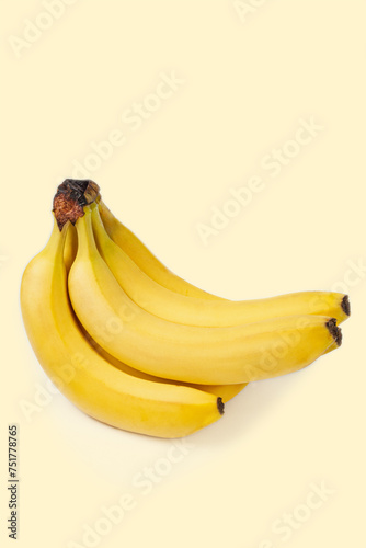 A bunch of bananas on a beige cream color background. Isolated with clipping masks. Beautiful yellow fruits. Conceptual photo. Vertical image.