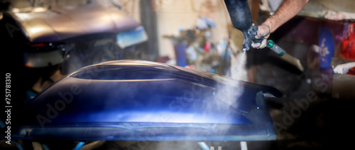 Fotografía painting a car in the garage with a spray gun blue