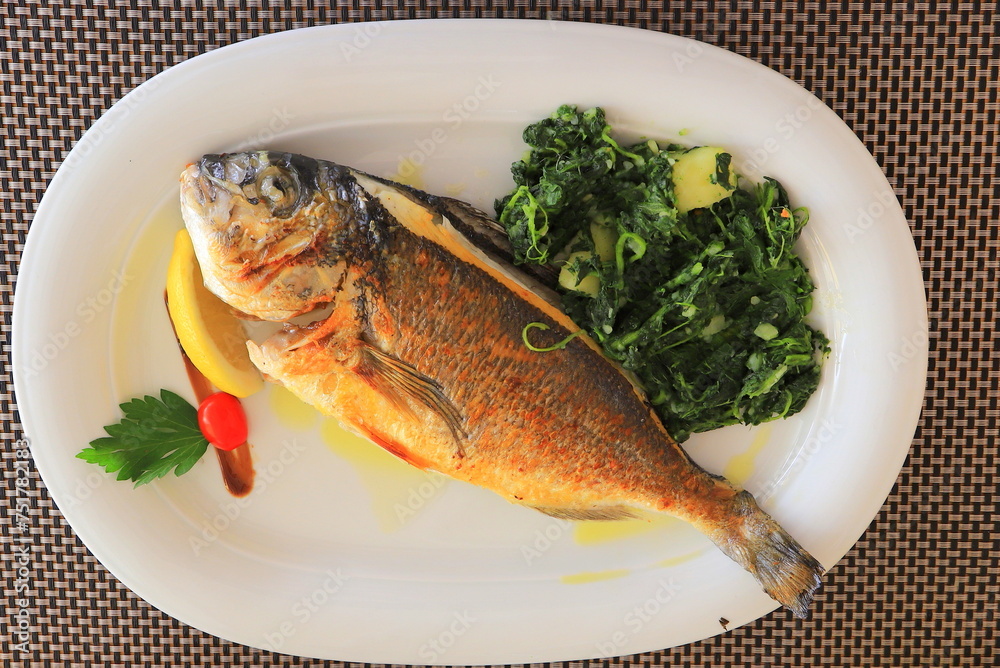 Fried fish with herbs on plate. Fresh Seafood in restaurant, cafe, hotel. Fish dish Fried fish with herbs on plate. Fresh Seafood in restaurant, cafe, hotel. Fish dish