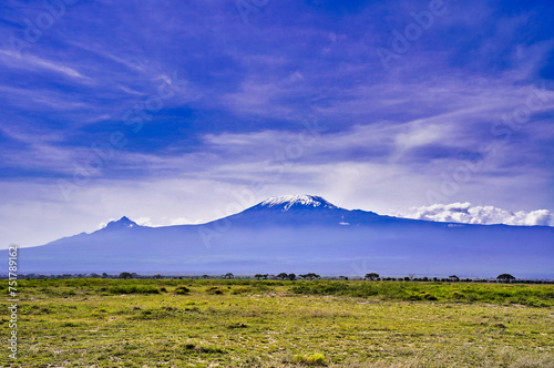 Africa's highest peak - Mount Kilimanjaro is seen on a brilliant sunlit day looming high over the vast savanna plains of the Amboseli national park, Kenya
