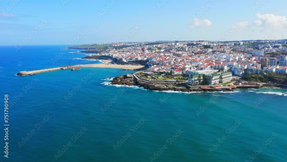 Drone is flying over ocean towards Beautiful resort touristic town. Aerial view - Beautiful travel destination with ocean rocky shore. Tourist place for surfing while vacation at Ericeira, Portugal Drone is flying over ocean towards Beautiful resort touristic town. Aerial view - Beautiful travel destination with ocean rocky shore. Tourist place for surfing while vacation at Ericeira, Portugal
