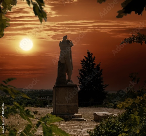A suggestive dawn illuminates the Statue of Trajan in a heroic pose at the archaeological complex of Italica, an ancient city with a strategic role in the Roman Empire, Santiponce, Seville. photo