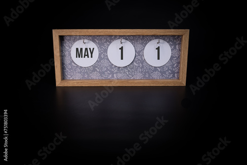 A wooden calendar block showing the date May 11th on a dark black background, save the date or date of an event concept.