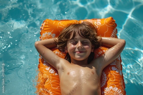 Happy cute boy resting on mat in swimming pool