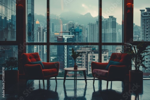 An inviting, warm interior space featuring comfortable armchairs and a coffee table with a city and mountain backdrop