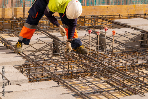 Trabajador de la construcción haciendo trabajos de armado, en una estructura de hormigón armado. © edu_mngs