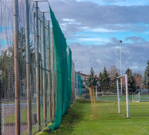 Pochmurne niebo nad stadionem sportowym – boiskiem piłkarskim  w styczniowe popołudnie. Trawiaste boisko do piłki nożnej tuż po ulewnym deszczu, niebo z chmurami deszczowymi nad głową. Widoczne bramki photo